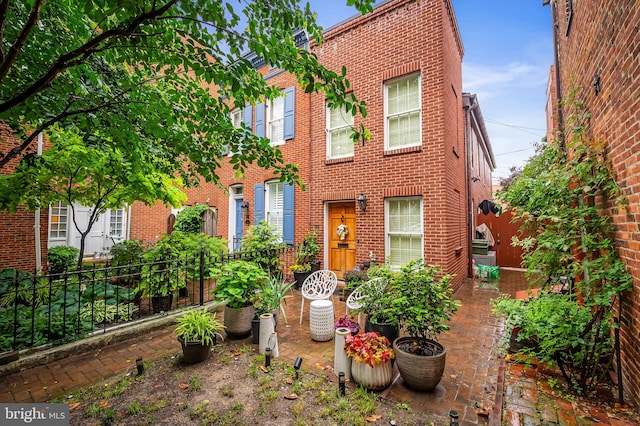 122 E Montgomery St, Baltimore, MD 21230 - view of property featuring brick siding and a patio