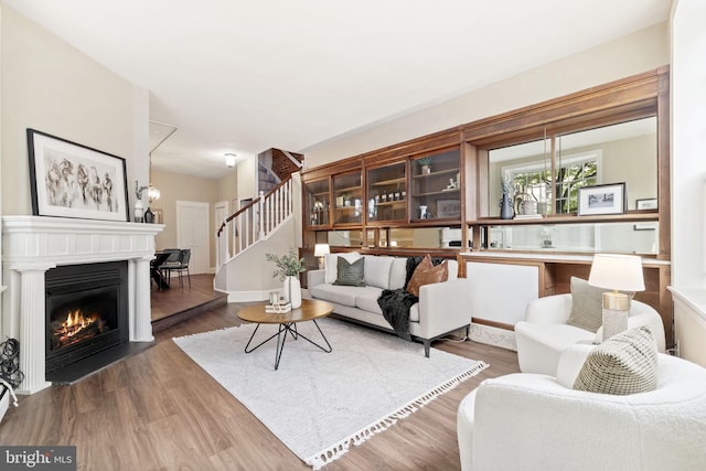 858 S Front St, Philadelphia, PA 19147 - living room featuring stairs, a glass covered fireplace, and wood finished floors