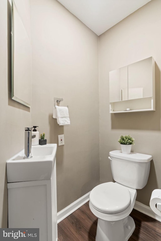 858 S Front St, Philadelphia, PA 19147 - half bathroom with toilet, wood finished floors, baseboards, and vanity