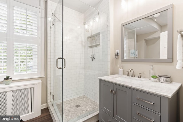 858 S Front St, Philadelphia, PA 19147 - bathroom with radiator heating unit, vanity, a stall shower, and wood finished floors