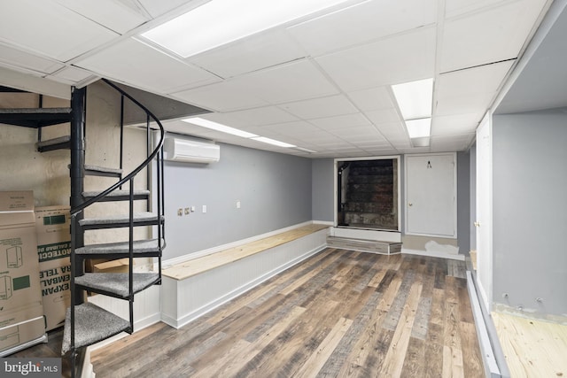 858 S Front St, Philadelphia, PA 19147 - finished basement with an AC wall unit, wood finished floors, stairs, a paneled ceiling, and baseboards