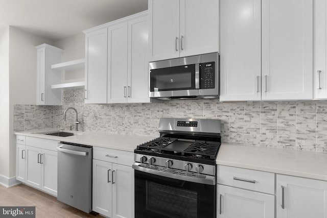 43288 Farringdon Sq, Broadlands, VA 20148 - kitchen with appliances with stainless steel finishes, open shelves, a sink, light countertops, and white cabinets