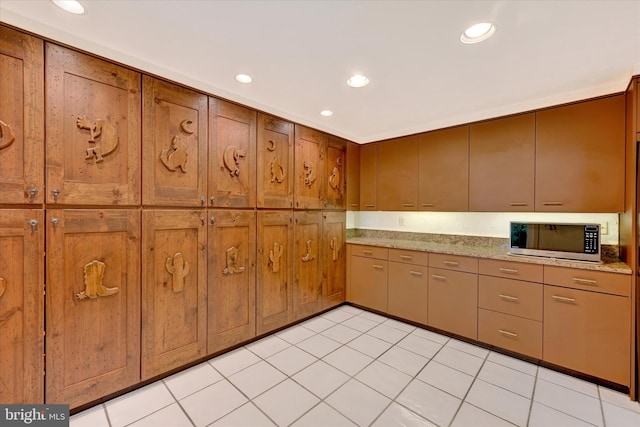 22 Woodholme Village Ct, Baltimore, MD 21208 - kitchen with stainless steel microwave, recessed lighting, brown cabinets, and light tile patterned floors