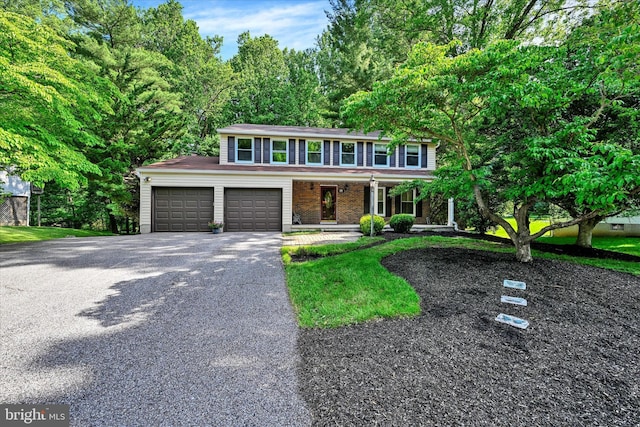 22 Woodholme Village Ct, Baltimore, MD 21208 - view of front facade featuring covered porch, driveway, and an attached garage