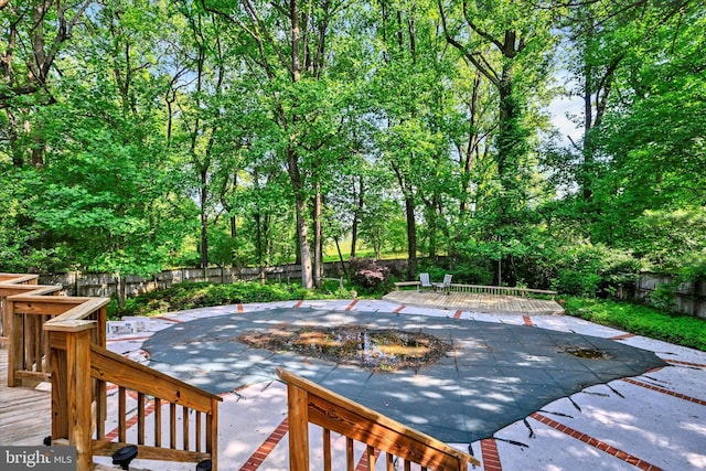 22 Woodholme Village Ct, Baltimore, MD 21208 - fenced backyard with a patio, a wooden deck, and view of scattered trees