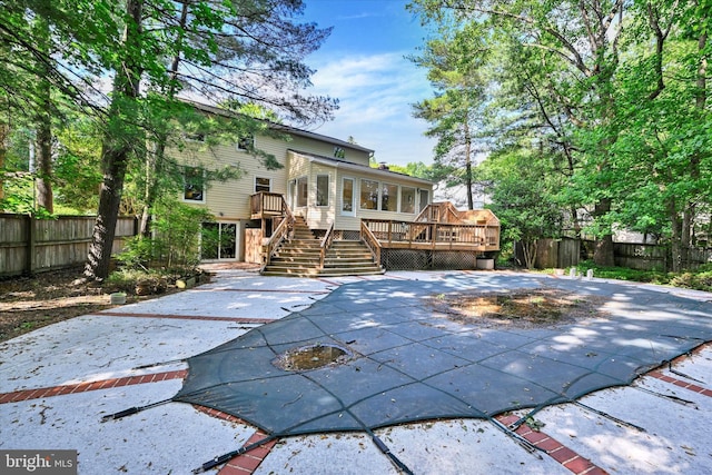 22 Woodholme Village Ct, Baltimore, MD 21208 - rear view of property featuring stairs, a deck, a fenced backyard, and a sunroom