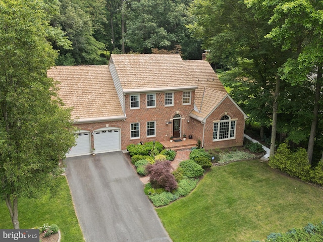 6805 Spout Ln, Fairfax Station, VA 22039 - colonial home with brick siding, asphalt driveway, a garage, and a front lawn