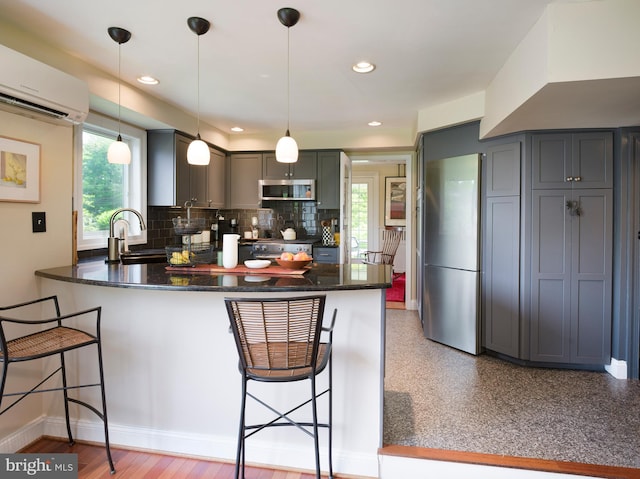442 Old Eagle School Rd, Wayne, PA 19087 - kitchen featuring stainless steel appliances, a peninsula, a wall mounted AC, a breakfast bar area, and recessed lighting