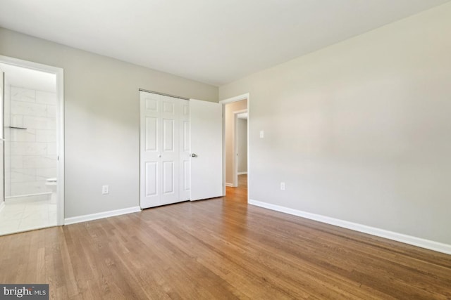 3713 Deming Dr, Suitland, MD 20746 - unfurnished bedroom featuring baseboards, wood finished floors, a closet, and ensuite bath