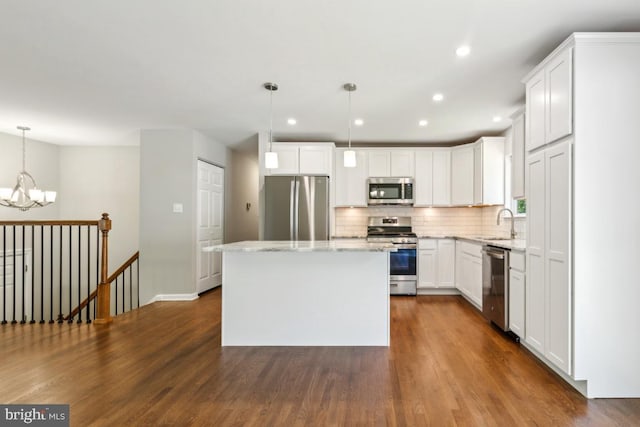 3713 Deming Dr, Suitland, MD 20746 - kitchen with stainless steel appliances, a sink, a chandelier, backsplash, and a center island