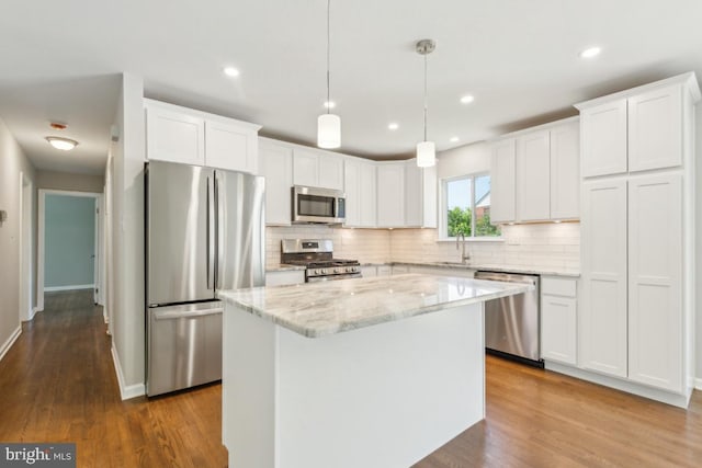 3713 Deming Dr, Suitland, MD 20746 - kitchen with stainless steel appliances, decorative backsplash, white cabinets, a kitchen island, and dark wood-style floors