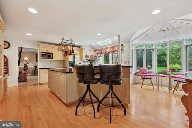 609 Ederer Ln, Ambler, PA 19002 - kitchen with cream cabinetry, stainless steel microwave, a skylight, light wood-type flooring, and healthy amount of natural light
