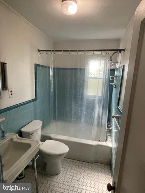 2632 Lenape Rd, Philadelphia, PA 19131 - full bath featuring shower / bath combination with curtain, toilet, tile walls, a sink, and wainscoting