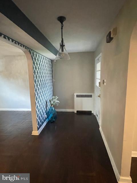2632 Lenape Rd, Philadelphia, PA 19131 - unfurnished dining area featuring radiator, arched walkways, baseboards, and wallpapered walls