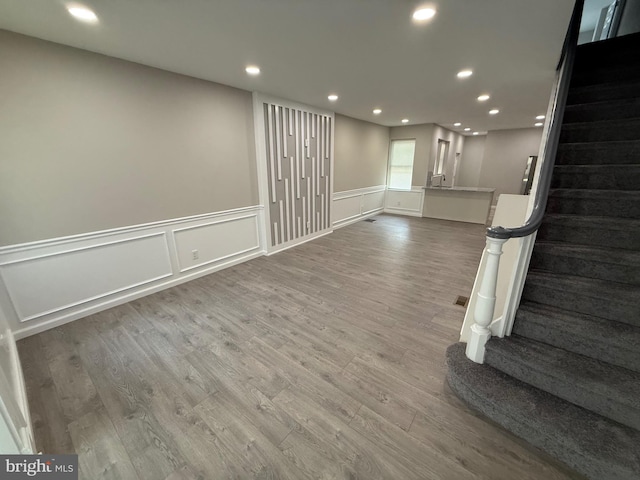 2127 Melvin St, Philadelphia, PA 19131 - basement with stairway, wood finished floors, recessed lighting, a wainscoted wall, and a decorative wall