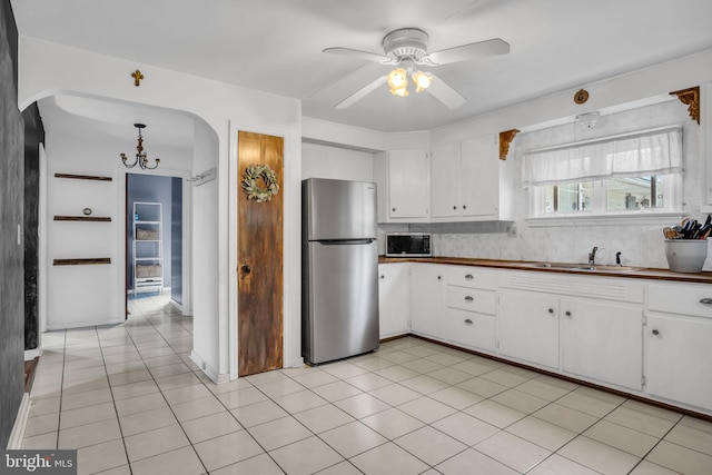 451 C St, Carlisle, PA 17013 - kitchen featuring appliances with stainless steel finishes, a sink, ceiling fan, arched walkways, and white cabinetry