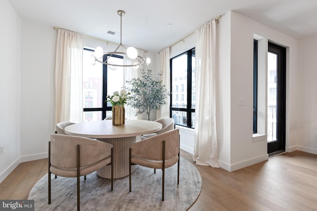 7175 12th St NW Unit 517, Washington, DC 20011 - dining area with a chandelier, light wood-style floors, and baseboards