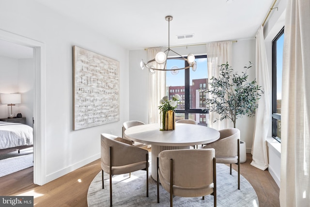 7175 12th St NW Unit 517, Washington, DC 20011 - dining area with a chandelier, wood finished floors, and baseboards