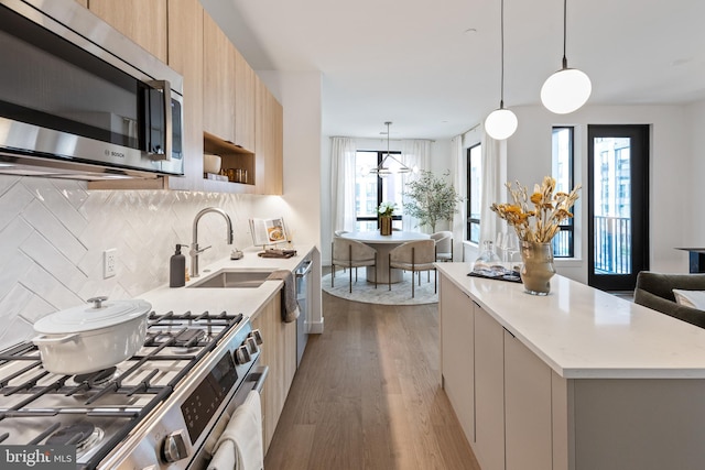 7175 12th St NW Unit 517, Washington, DC 20011 - kitchen with appliances with stainless steel finishes, modern cabinets, wood finished floors, light brown cabinetry, and backsplash