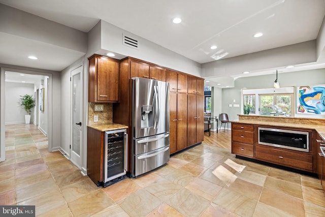 8901 Potomac Station Ln, Potomac, MD 20854 - kitchen featuring wine cooler, stainless steel fridge with ice dispenser, recessed lighting, brown cabinets, and tasteful backsplash