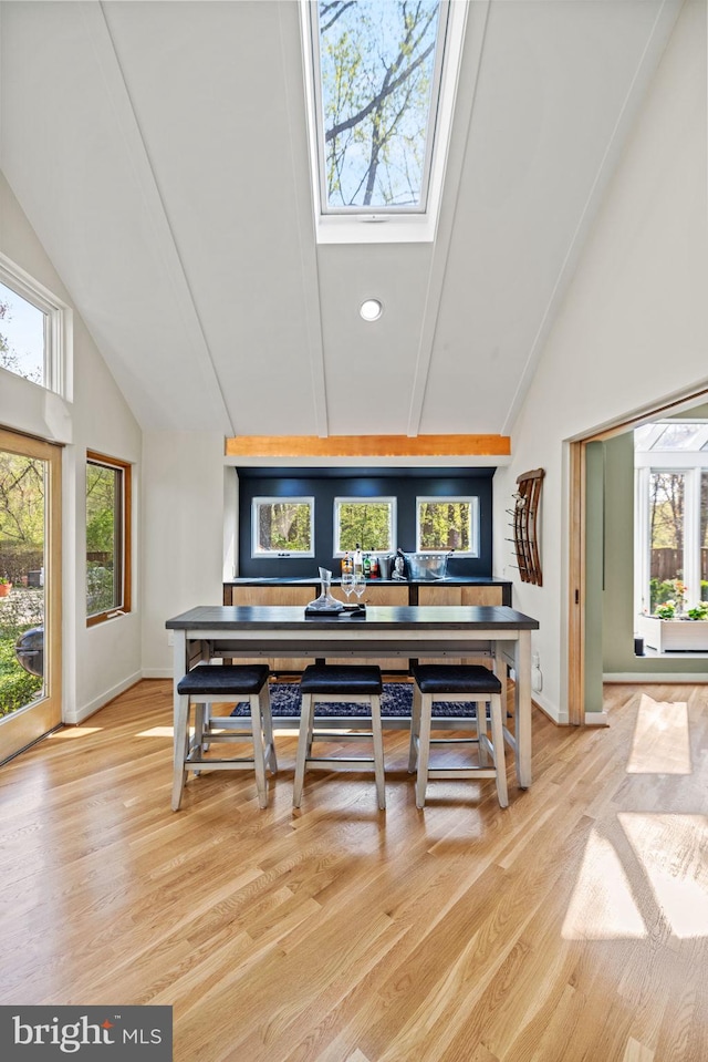 8901 Potomac Station Ln, Potomac, MD 20854 - dining space with high vaulted ceiling, light wood finished floors, a skylight, and baseboards