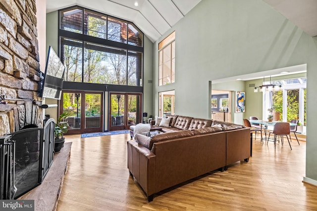 8901 Potomac Station Ln, Potomac, MD 20854 - living room with high vaulted ceiling, wood finished floors, healthy amount of natural light, a chandelier, and a stone fireplace