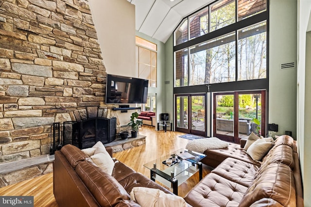 8901 Potomac Station Ln, Potomac, MD 20854 - living area with high vaulted ceiling, wood finished floors, a stone fireplace, and healthy amount of natural light