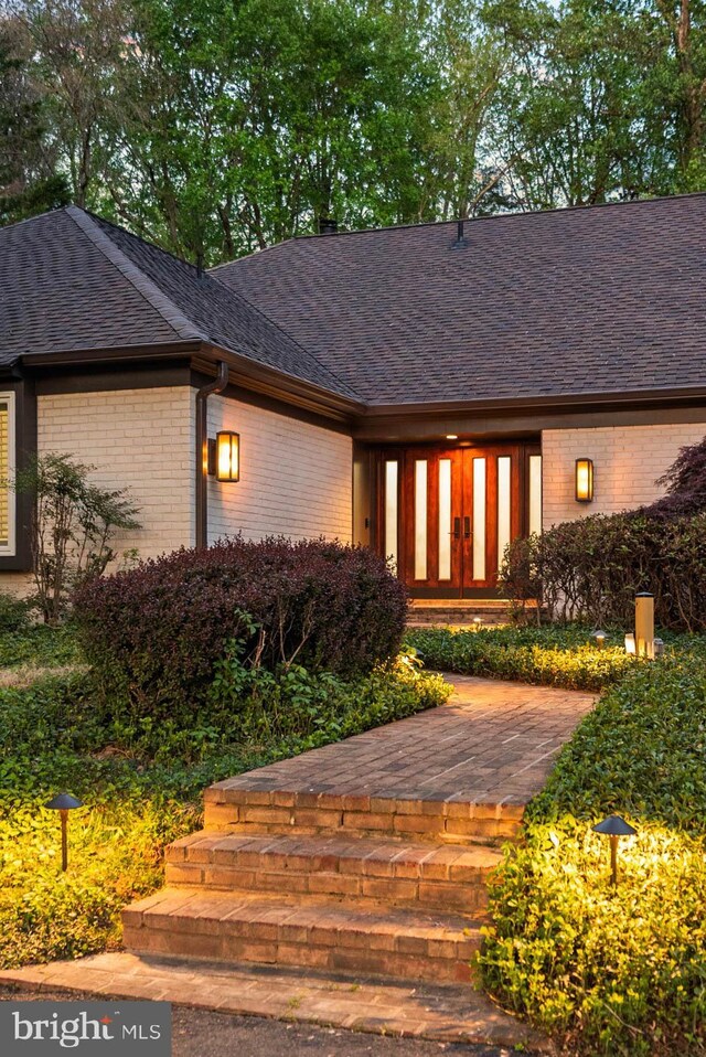 8901 Potomac Station Ln, Potomac, MD 20854 - view of exterior entry featuring brick siding and roof with shingles