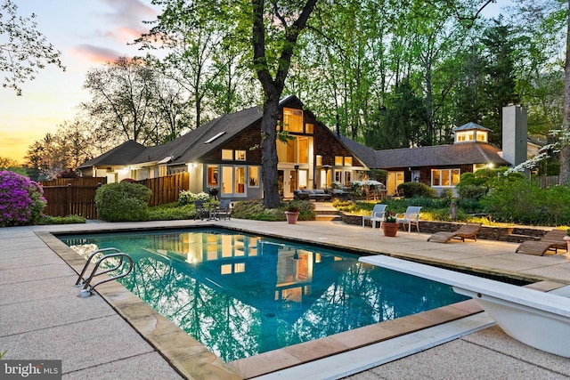 8901 Potomac Station Ln, Potomac, MD 20854 - pool at dusk with a patio and a diving board