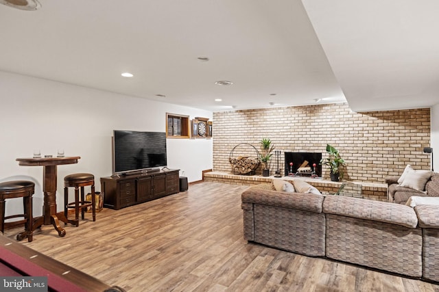 8901 Potomac Station Ln, Potomac, MD 20854 - living room featuring brick wall, wood finished floors, baseboards, recessed lighting, and a fireplace