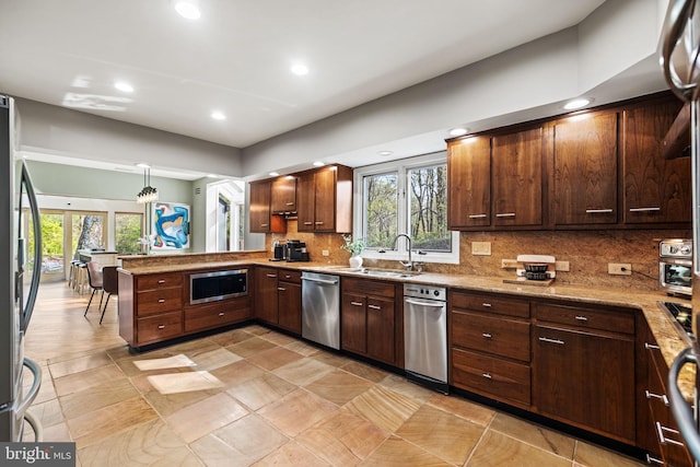8901 Potomac Station Ln, Potomac, MD 20854 - kitchen featuring appliances with stainless steel finishes, a sink, a peninsula, backsplash, and recessed lighting