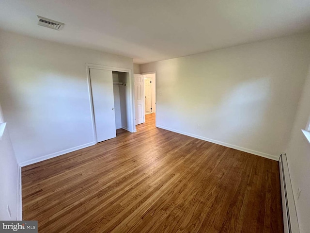 127 Homestead Dr, Doylestown, PA 18901 - unfurnished bedroom with a baseboard heating unit, wood finished floors, baseboards, and a closet