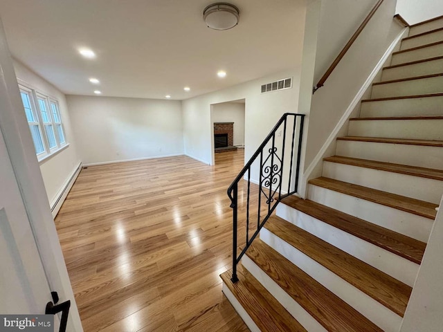 127 Homestead Dr, Doylestown, PA 18901 - stairway with a baseboard heating unit, recessed lighting, wood finished floors, a fireplace, and baseboards