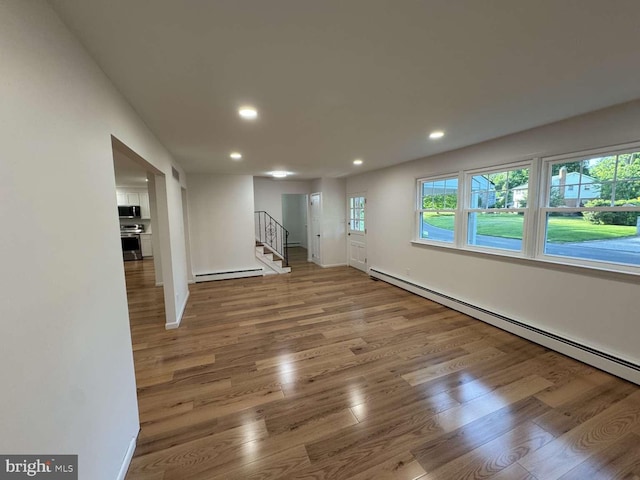 127 Homestead Dr, Doylestown, PA 18901 - basement featuring a baseboard radiator, recessed lighting, wood finished floors, stairs, and baseboard heating