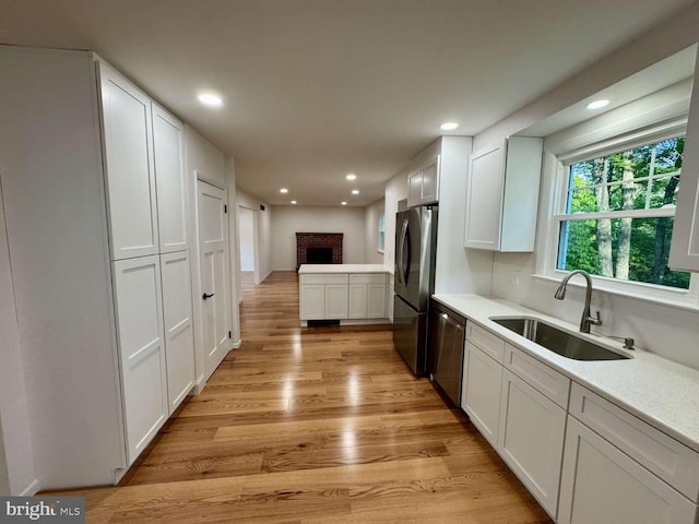 127 Homestead Dr, Doylestown, PA 18901 - kitchen featuring a sink, appliances with stainless steel finishes, white cabinetry, light wood-style floors, and light countertops