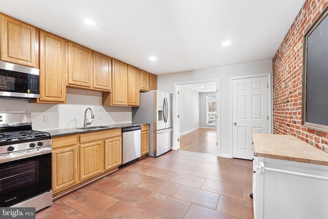 1622 E Clement St, Baltimore, MD 21230 - kitchen with stainless steel appliances, a sink, recessed lighting, brick wall, and baseboards