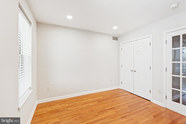 1622 E Clement St, Baltimore, MD 21230 - unfurnished bedroom with light wood finished floors, multiple windows, baseboards, recessed lighting, and a closet