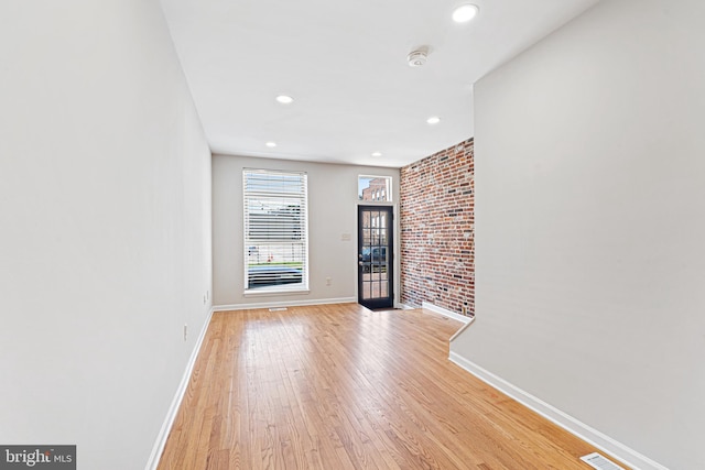 1622 E Clement St, Baltimore, MD 21230 - unfurnished living room featuring baseboards, light wood-style floors, recessed lighting, and brick wall