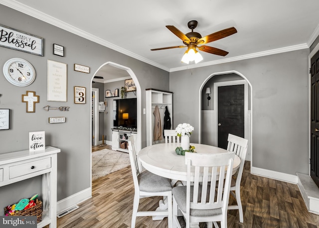 1200 Hessian Ave, National Park, NJ 08063 - dining space featuring arched walkways, ceiling fan, wood finished floors, baseboards, and crown molding