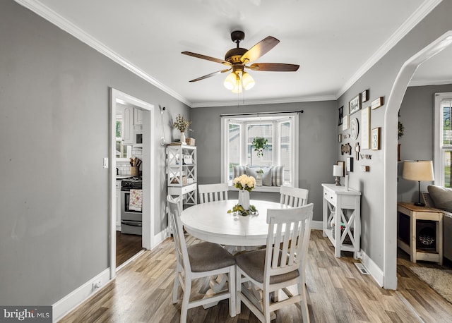 1200 Hessian Ave, National Park, NJ 08063 - dining space with plenty of natural light, arched walkways, light wood finished floors, a ceiling fan, and ornamental molding