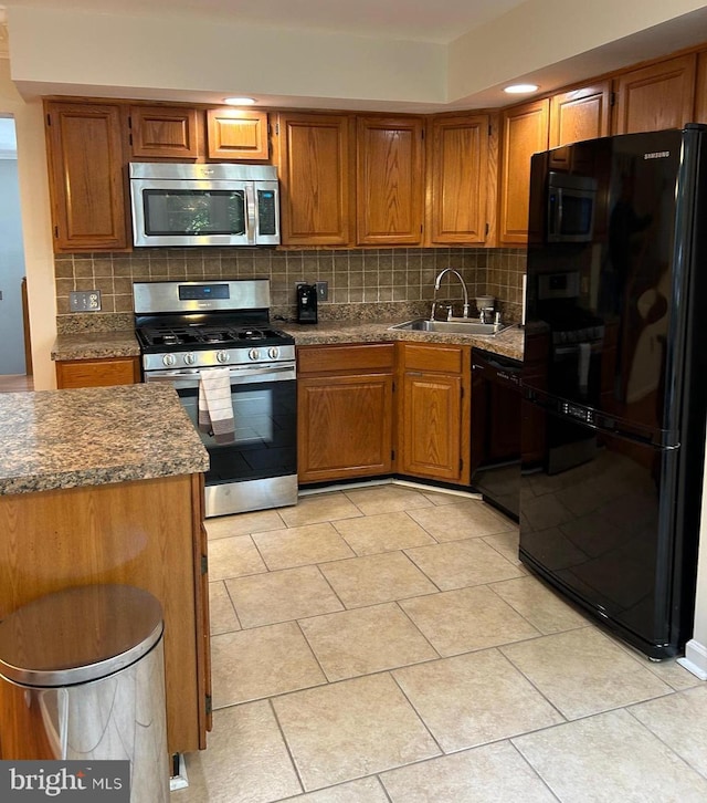15496 Travailer Ct, Woodbridge, VA 22193 - kitchen featuring black appliances, tasteful backsplash, a sink, and brown cabinets
