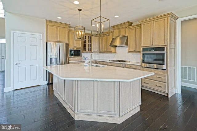 33557 Downing Cir, Lewes, DE 19958 - kitchen featuring appliances with stainless steel finishes, under cabinet range hood, a chandelier, dark wood-type flooring, and light countertops