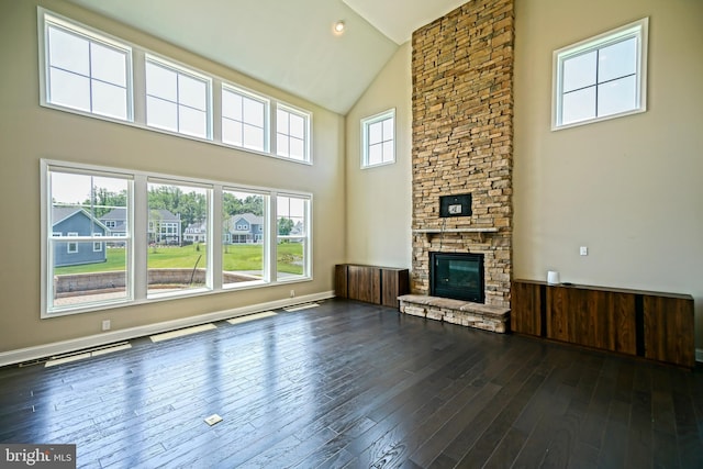 33557 Downing Cir, Lewes, DE 19958 - unfurnished living room with high vaulted ceiling, a stone fireplace, and dark wood-style flooring