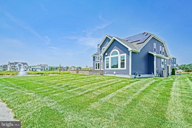 33557 Downing Cir, Lewes, DE 19958 - view of property exterior featuring a yard, a water view, and solar panels