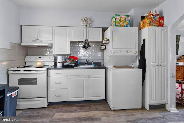 1326 Pine Grove Ave, Baltimore, MD 21237 - kitchen with electric stove, under cabinet range hood, stacked washing machine and dryer, a sink, and white cabinetry