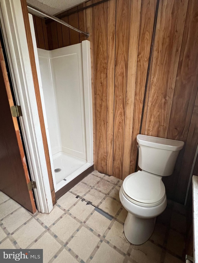 221 S State St, Talmage, PA 17580 - full bath featuring a stall shower, wood walls, toilet, and inlaid floor details