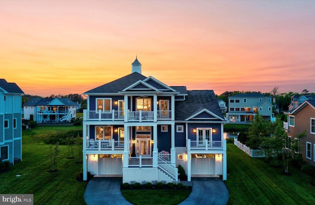 64 Blackpool Rd, Rehoboth Beach, DE 19971 - coastal inspired home with a balcony, an attached garage, a front yard, driveway, and roof with shingles