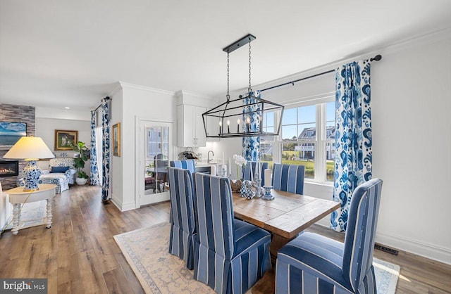 64 Blackpool Rd, Rehoboth Beach, DE 19971 - dining room with ornamental molding, baseboards, wood finished floors, and a chandelier