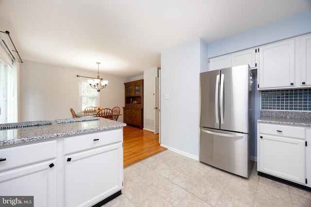 106 Everest Cir Unit 106, West Chester, PA 19382 - kitchen with freestanding refrigerator, decorative backsplash, white cabinets, and a chandelier