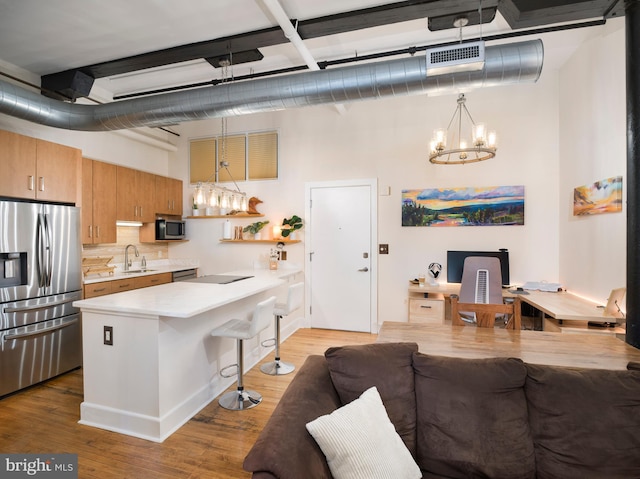 200 Lincoln Ave Unit 213, Phoenixville, PA 19460 - kitchen featuring stainless steel appliances, a chandelier, a sink, light countertops, and a breakfast bar area